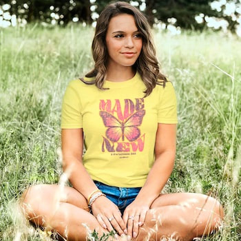 Christian Tshirt on Young Lady sitting in grass that says Made New